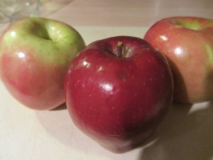 Two Fuji apples and one Red Delicious apple.