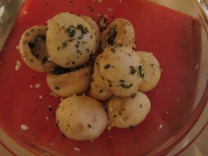 Mushroom caps tossed with olive oil, rosemary, thyme, and garlic.