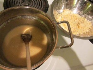 Adding cheese, handful by handful.