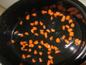 Carrot in roasting pan with olive oil.