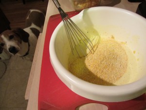 Adding dry ingredients to wet ingredients.