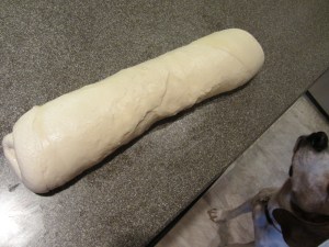 Dough rolled up to be cut into thirds.