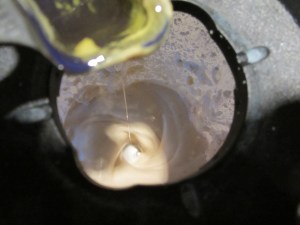 Olive oil drizzled into dressing.