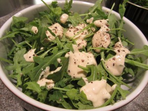 Tofu Caesar dressing over arugula.