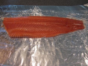 First salmon fillet placed on top of sprinkled cure.