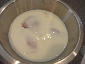 Buttermilk poured over chicken pieces.