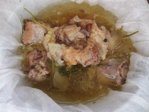 Straining the broth through cheesecloth.