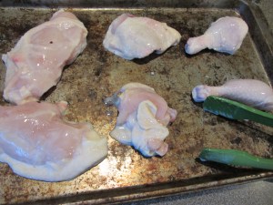 Chicken pieces on a baking sheet.