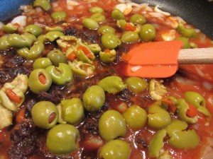 Tomato juice, balsamic vinegar, raisins, and green olives added to pan.