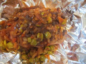 Remaining olive mixture poured over meat.